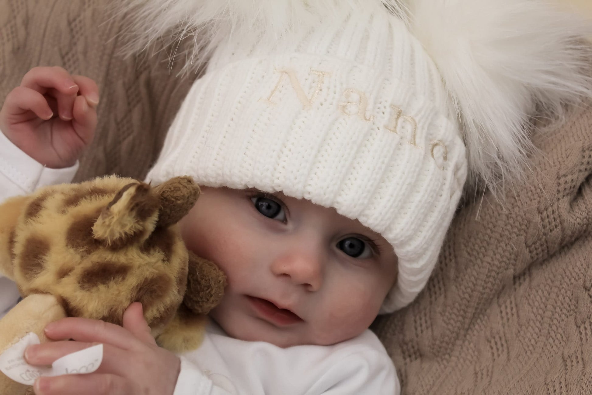 Cute newborn baby with white knitted winter hat