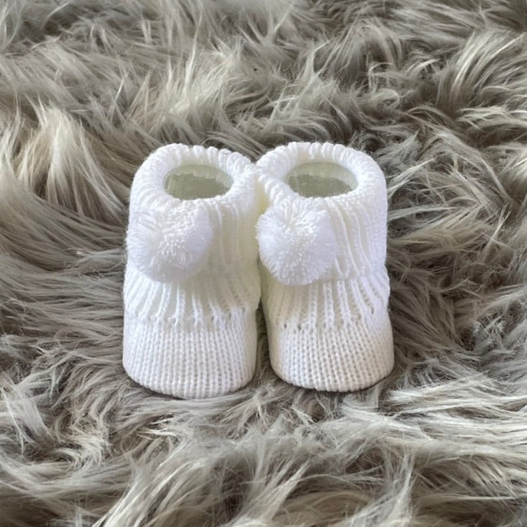 white knitted pom pom baby booties