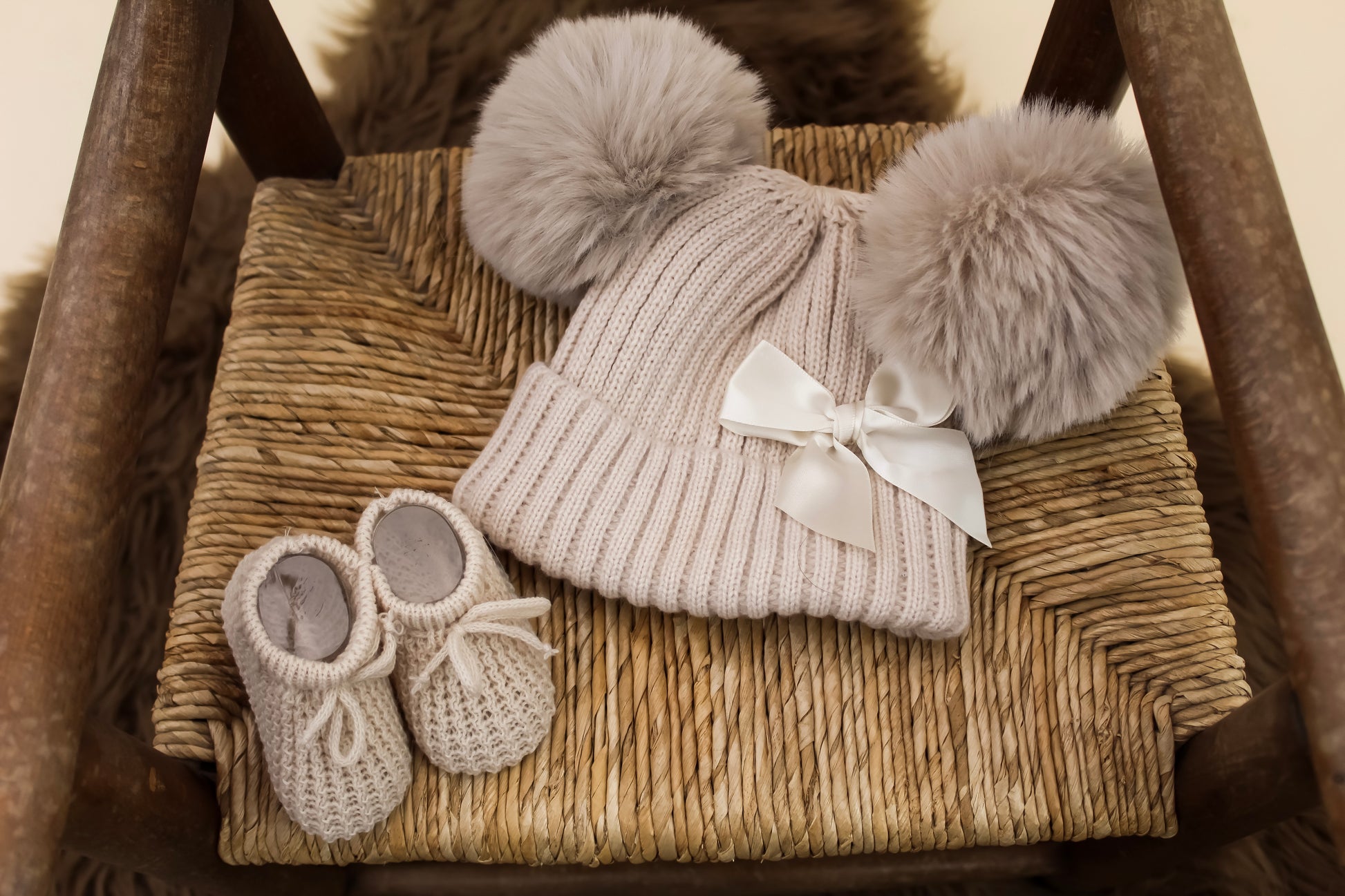 cream knitted hat with bow detail and matching nude nitted baby booties