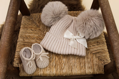 cream knitted hat with bow detail and matching nude nitted baby booties