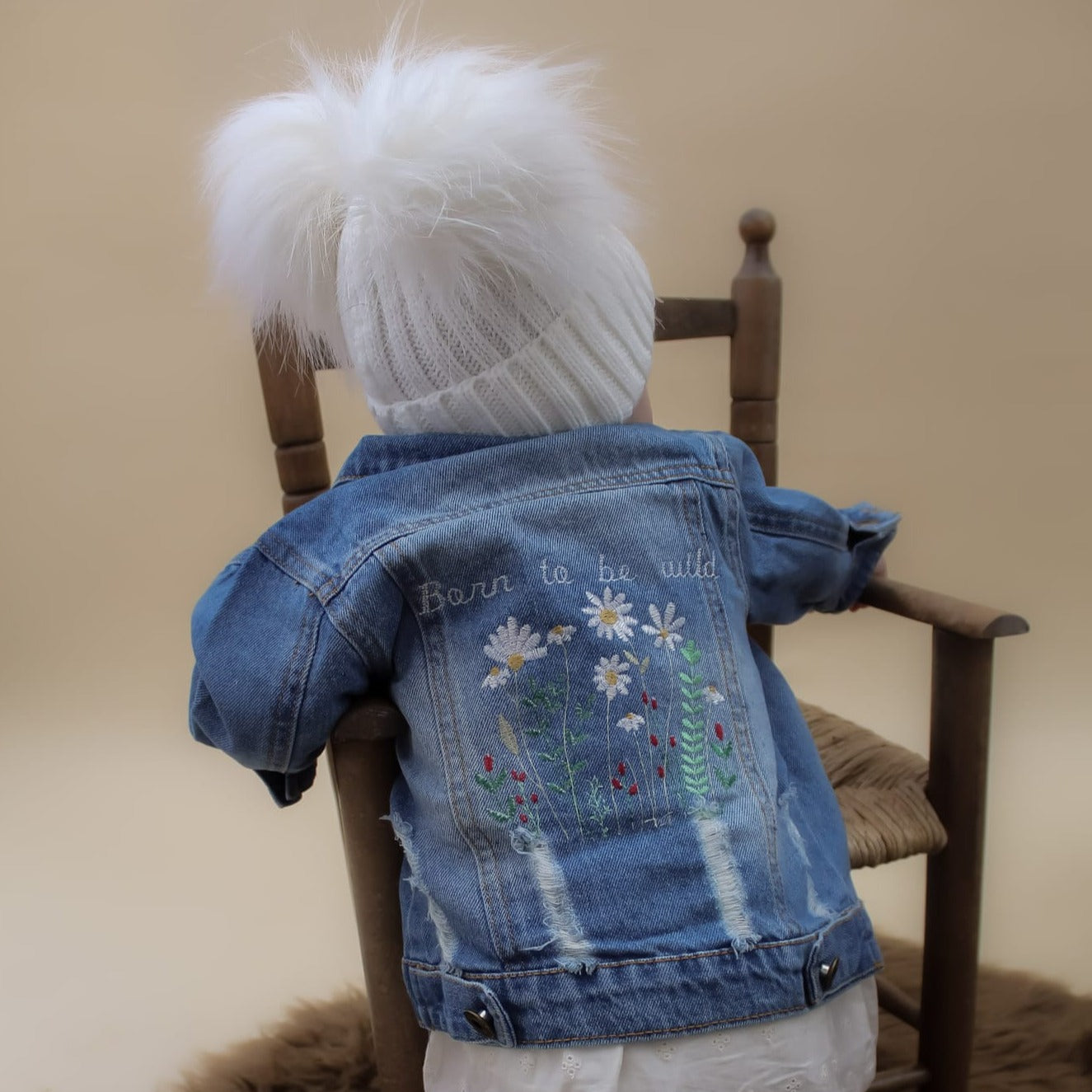 white knitted baby pom pom hat and fkoral denim jacket